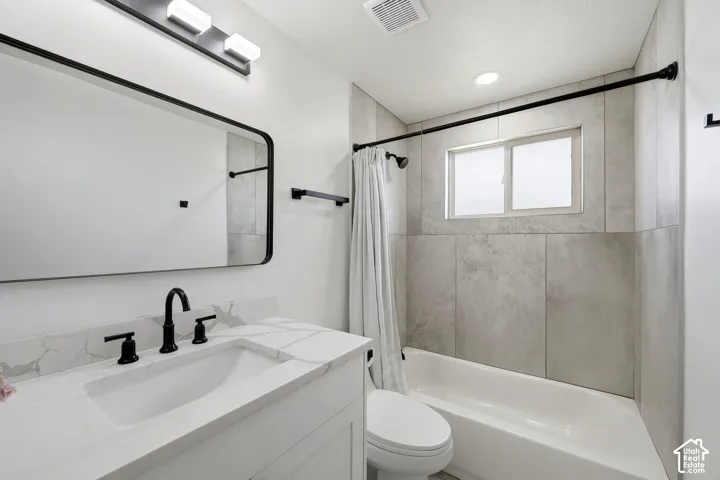 White vanity with integrated sink, black fixtures, and a framed mirror
