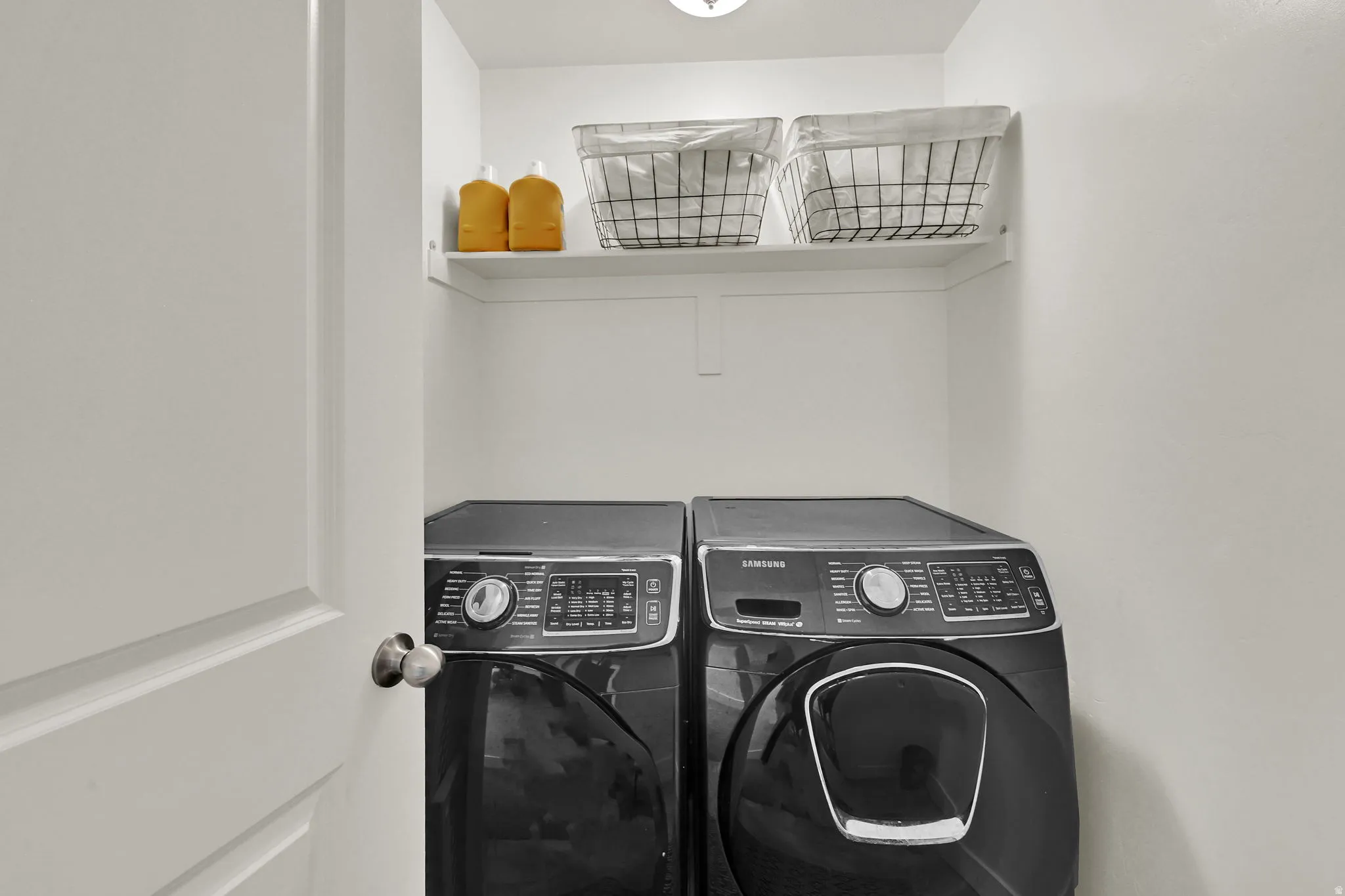 Dedicated laundry area with a white built-in shelf. Located on the same floor as the bedrooms for convenience