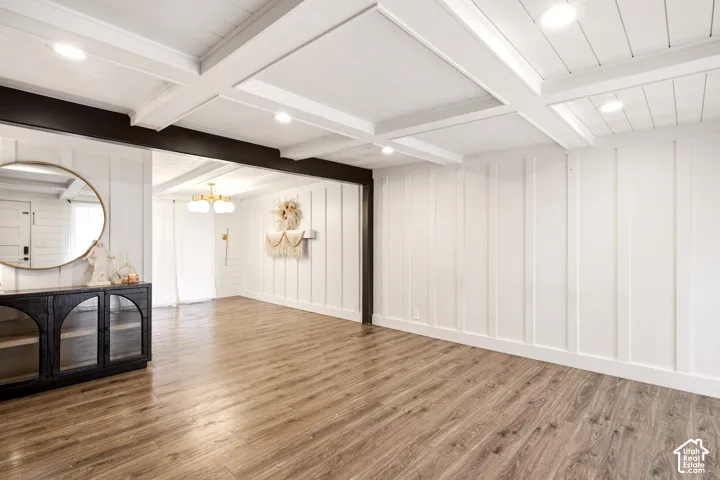 Coffered ceiling with recessed lighting, board and batten wall paneling, and wood-finish flooring