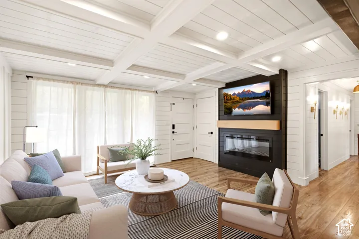 THIS ROOM OS VIRTUALLY STAGED Coffered ceilings, white shiplap wall paneling, wood-finish flooring, and a floor-to-ceiling dark-toned fireplace feature wall with an integrated linear electric insert