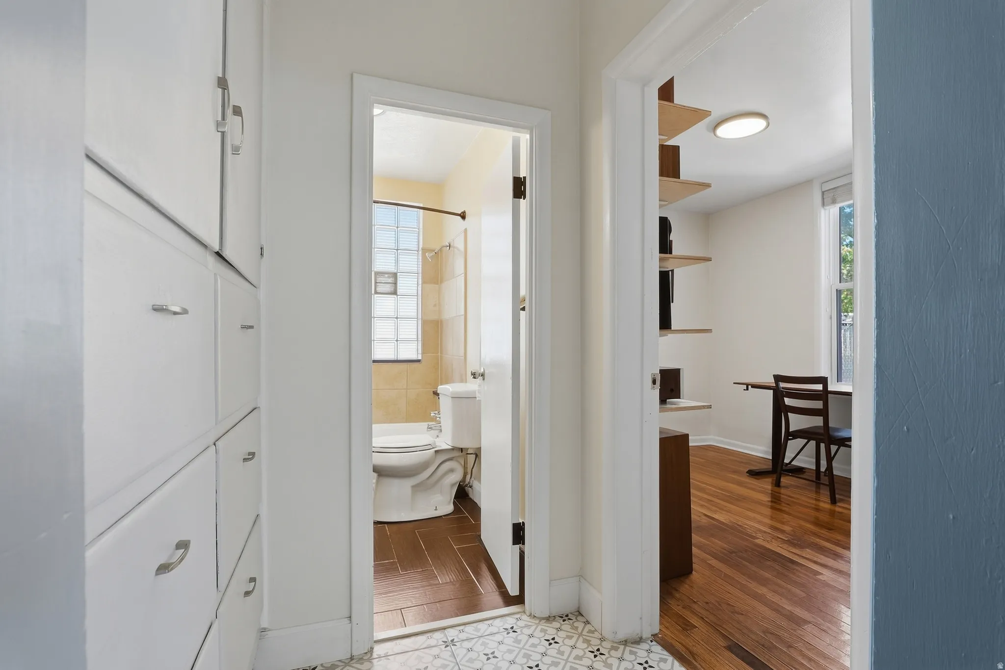Built-in storage cabinetry, patterned floor tile, wood-finish flooring, glass block window, recessed ceiling lighting