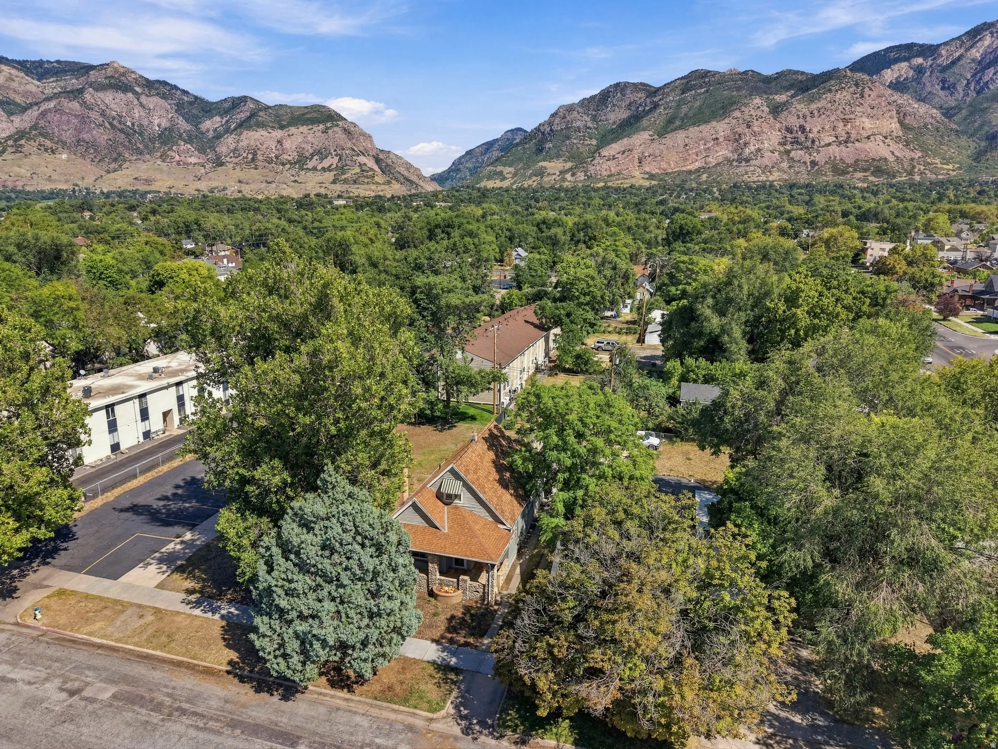 Gable roofline, mature trees, and mountain backdrop