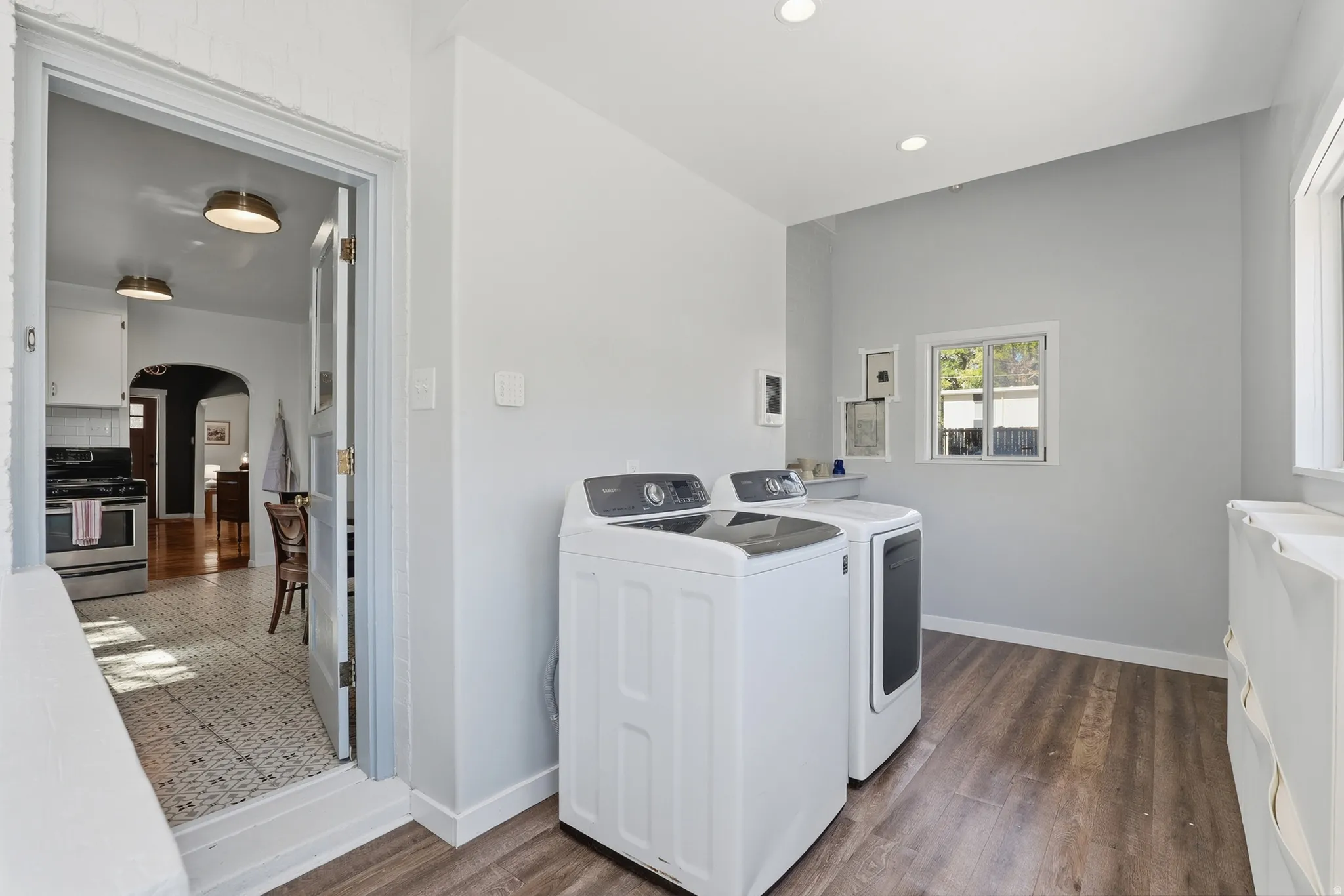 Light-filled utility space featuring wood-finish flooring, recessed lighting, and a window