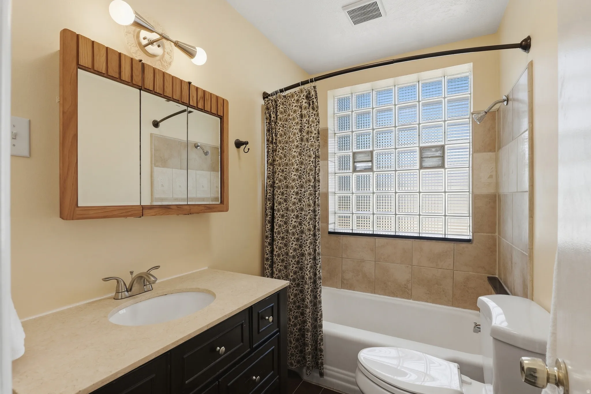 Built-in vanity with a single basin sink and dark wood-finish cabinetry