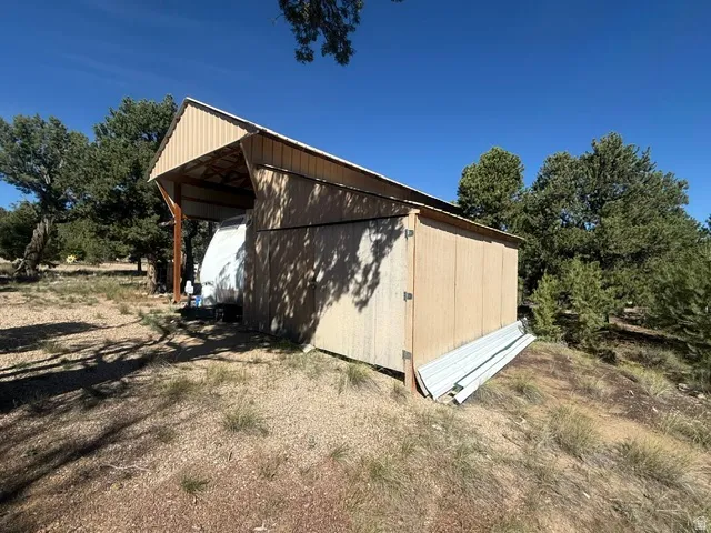 Storage structure featuring a pitched roof and light-colored siding