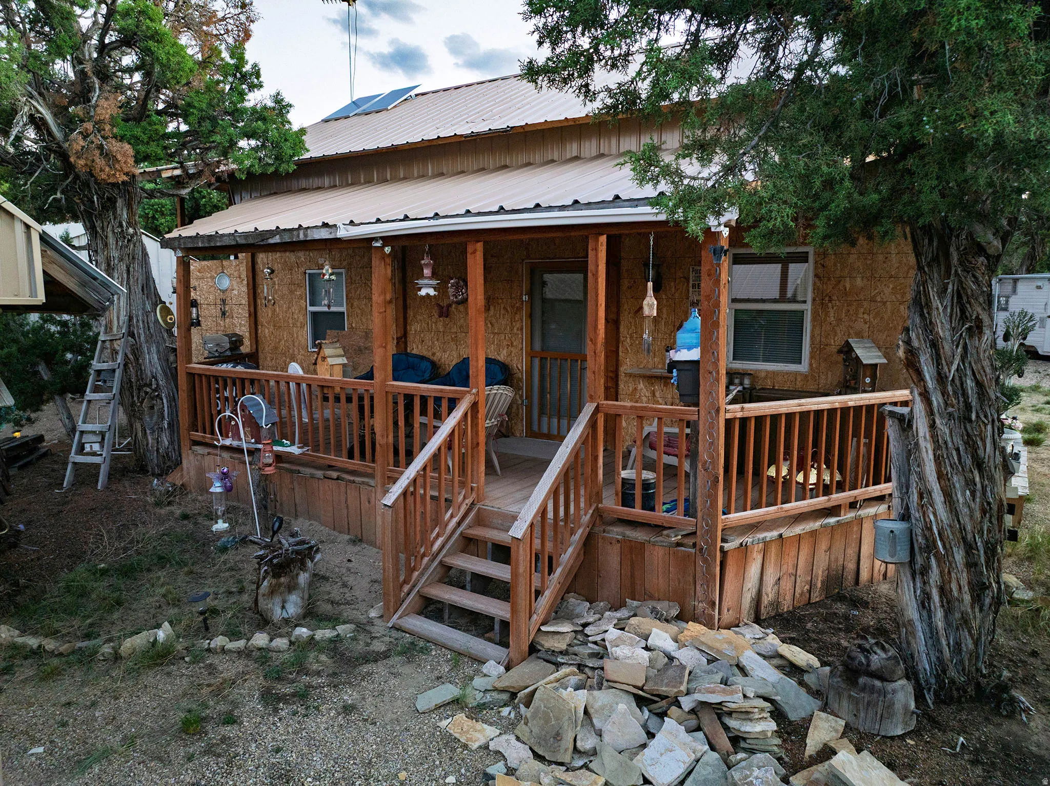 Wood-sided exterior featuring a covered porch, metal roof, and wood deck with railing