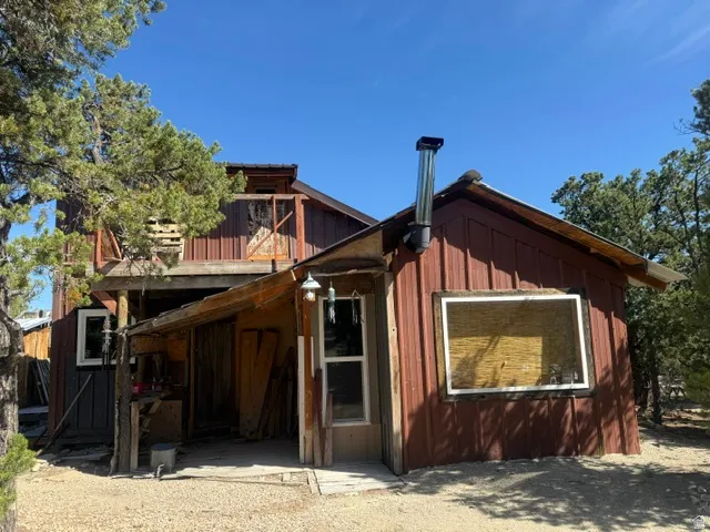Multi-level exterior with board and batten siding, corrugated metal roofing, and a prominent chimney