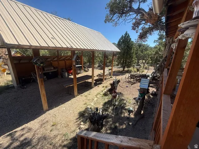 Covered outdoor living space featuring a metal roof and exposed wood beams