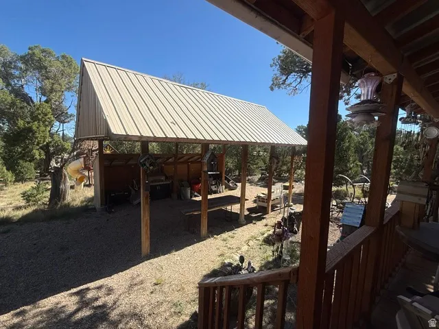 Covered outdoor structure with a metal roof and wood posts, set on a gravel surface