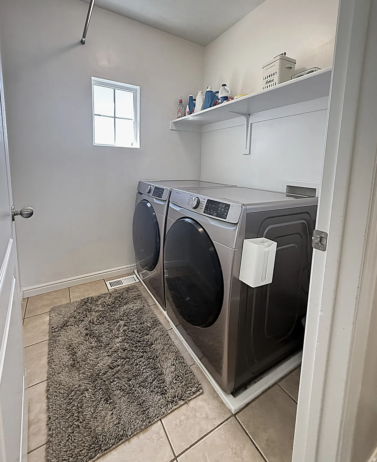 Tile flooring with a single window and wall-mounted shelving