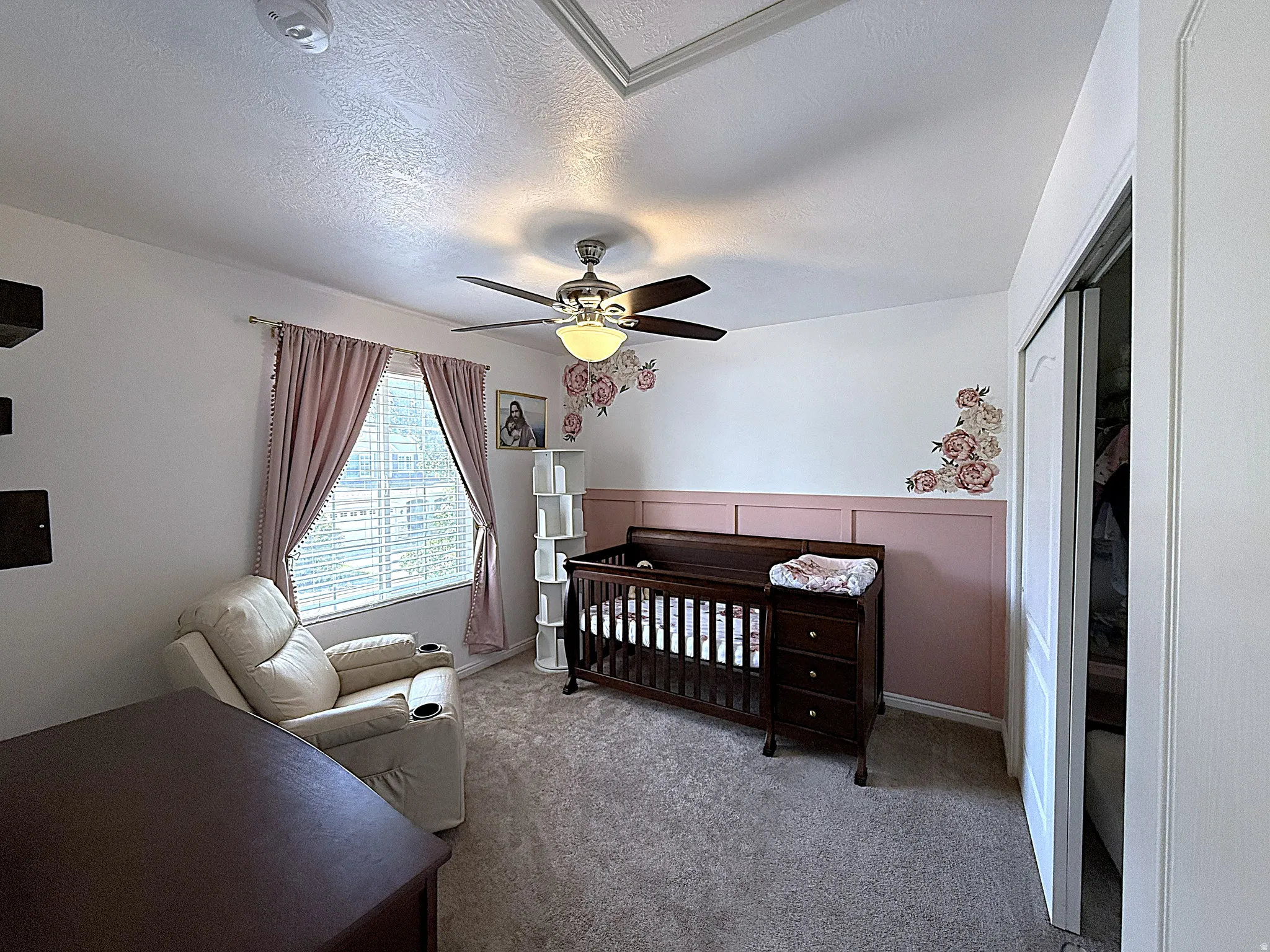 Carpeted room featuring a ceiling fan with integrated lighting, a window with blinds, and a built-in closet with bifold doors