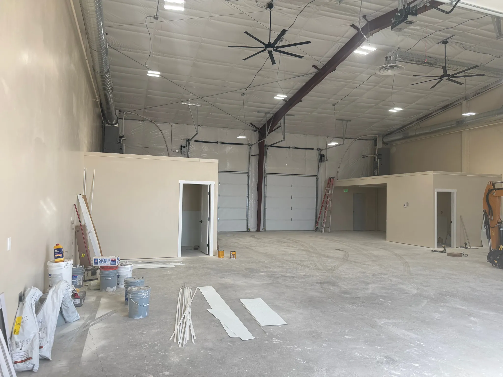 Expansive open interior with a reinforced concrete floor, exposed ductwork, and high ceilings
