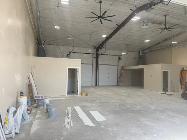 Expansive open interior with a reinforced concrete floor, exposed ductwork, and high ceilings