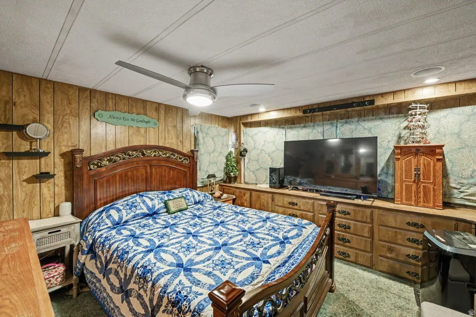Wood-paneled walls with built-in cabinetry, recessed lighting, and a ceiling fan