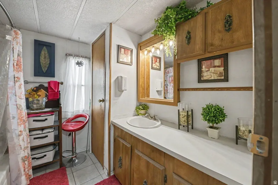 Bathroom featuring a vanity with a countertop, wood-finish cabinetry, and a mirrored medicine cabinet