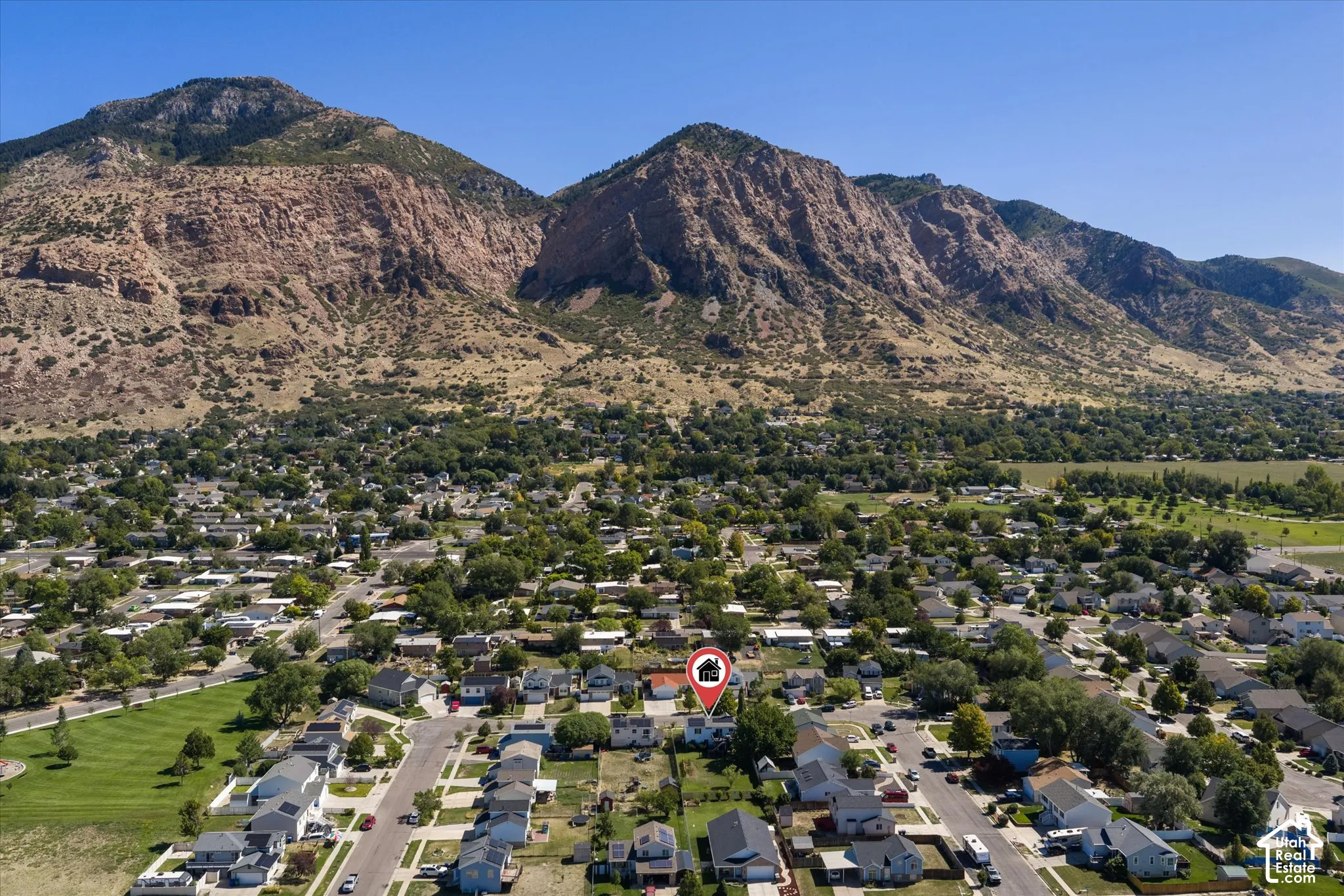 Mountain backdrop, mature trees, residential neighborhood, paved streets, green spaces