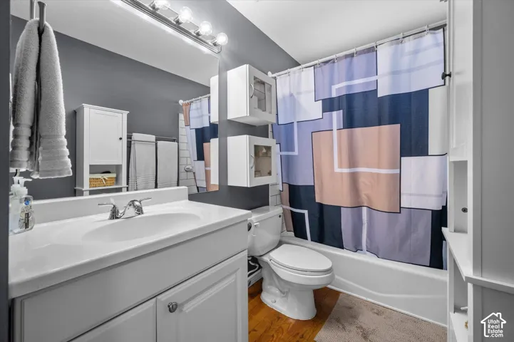 Single vanity with integrated sink, chrome faucet, wall-mounted mirror, and overhead four-bulb light fixture