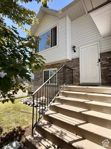 Front entry with concrete steps and a black metal railing