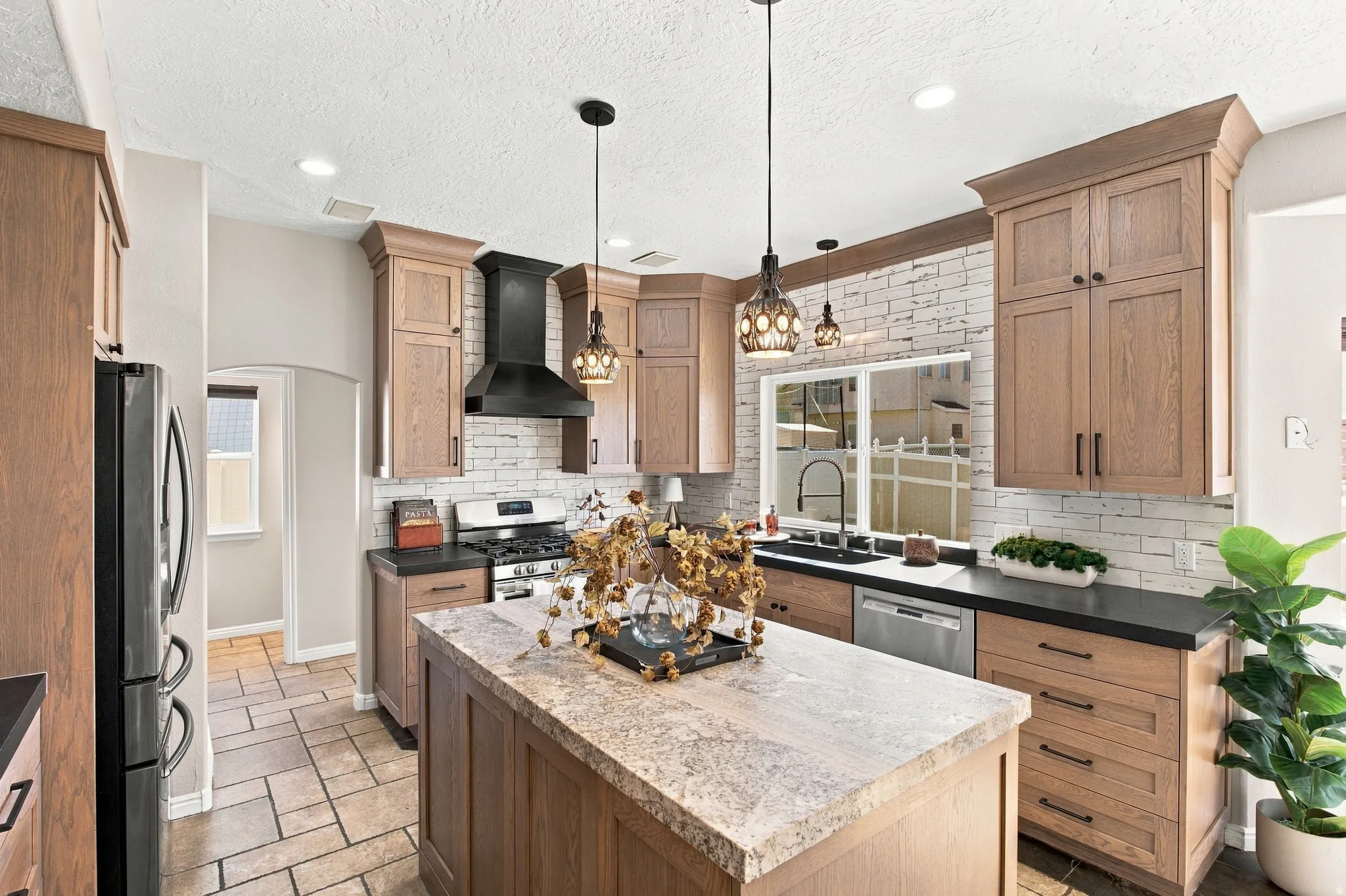 White oak cabinets, Monte Cristo Satin granite island and Cabraian black satin granite countertops. Matte balck externally vented range hood.