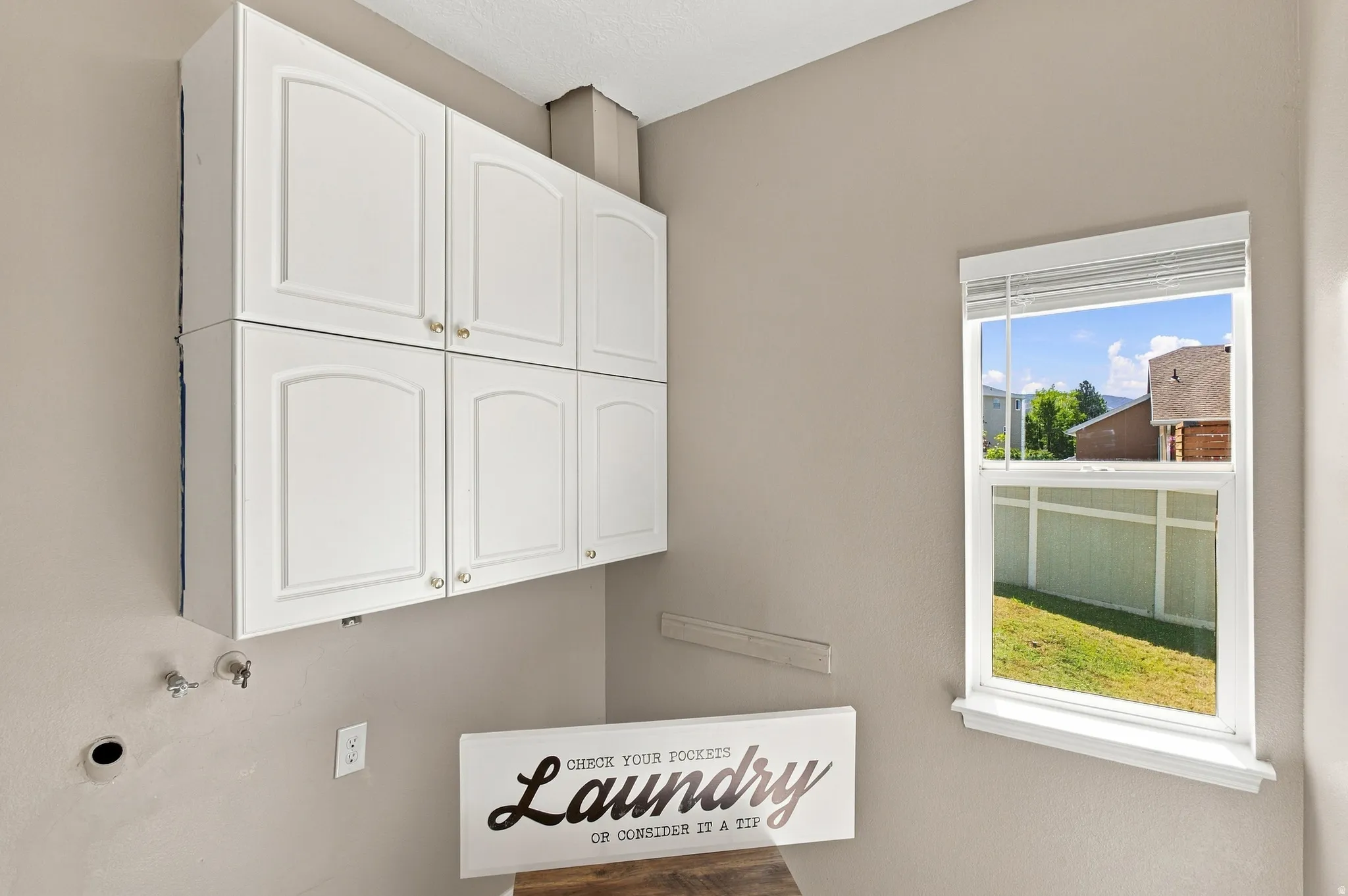 Laundry room with laundry chute going into the cabinet on the right.
