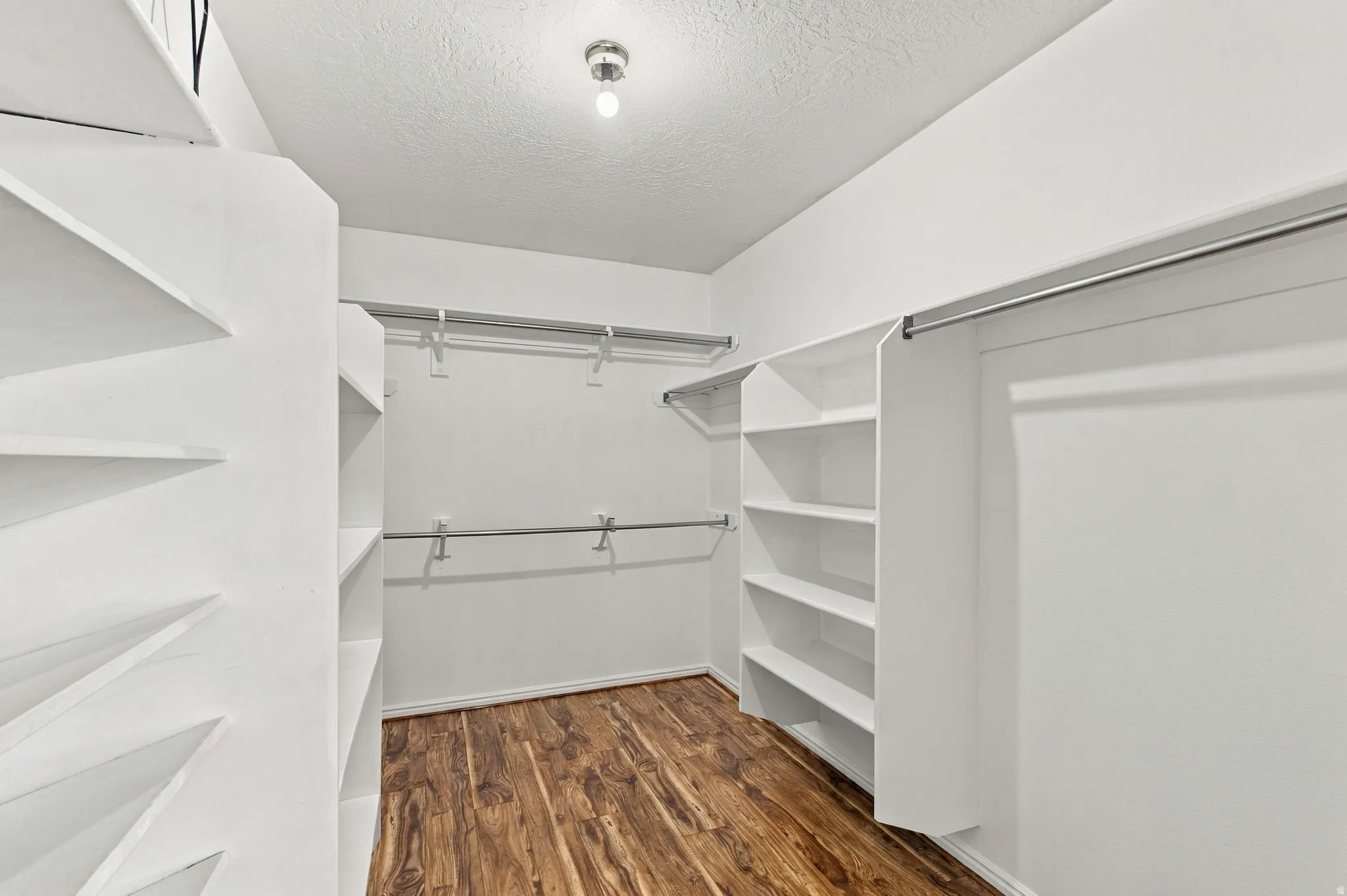 Spacious walk in closet with plenty of shelving in primary suite.