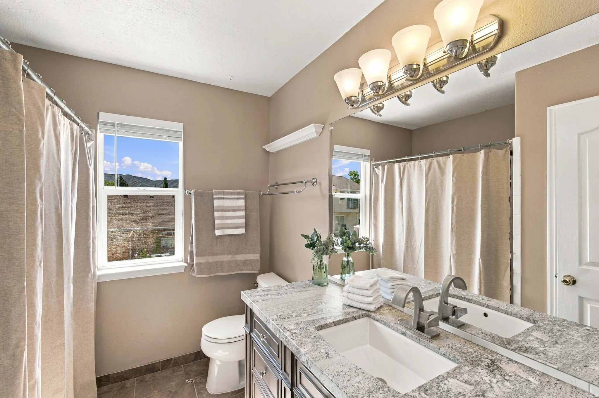 Full bathroom with granite countertop, high end vanity, bathtub and shower.