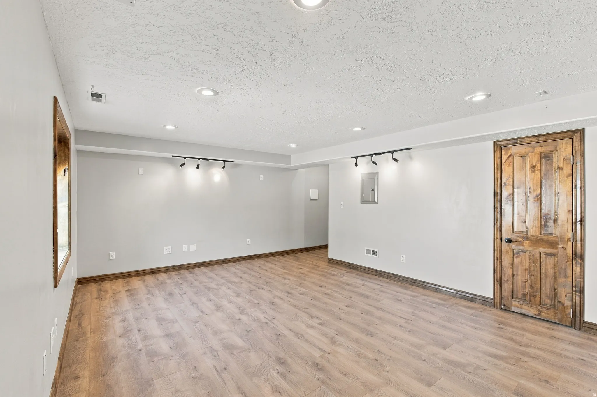 Family room in basement with recessed ceiling, wired for suround sound, ethernet wired, beautiful alder doors, windows and baseboards.  The closet has the same lovely flooring.