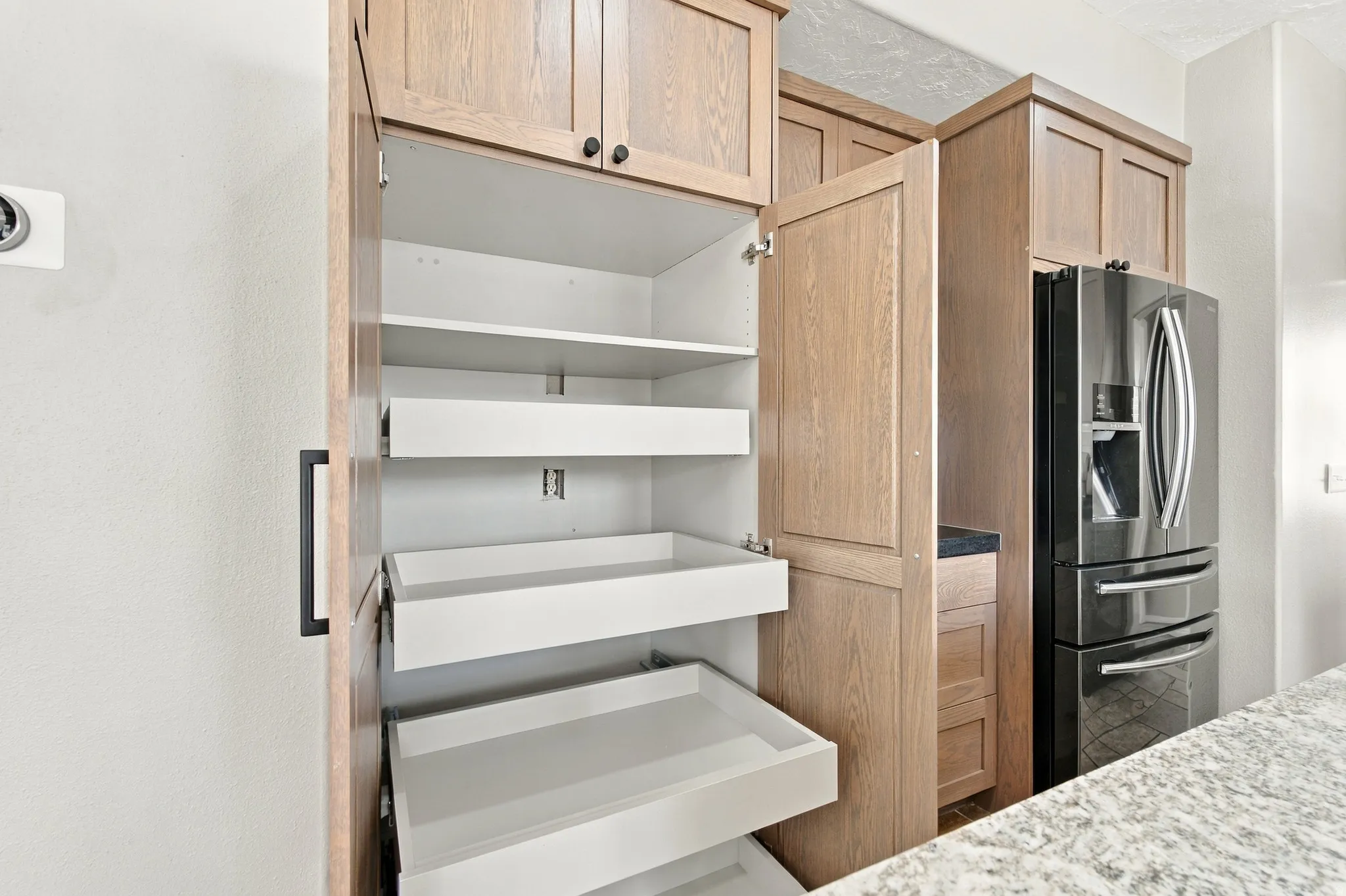 Pull out shelves in floor to ceiling pantry with slow close doors.