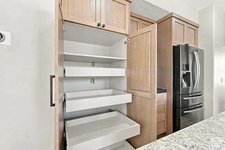 Pull out shelves in floor to ceiling pantry with slow close doors.