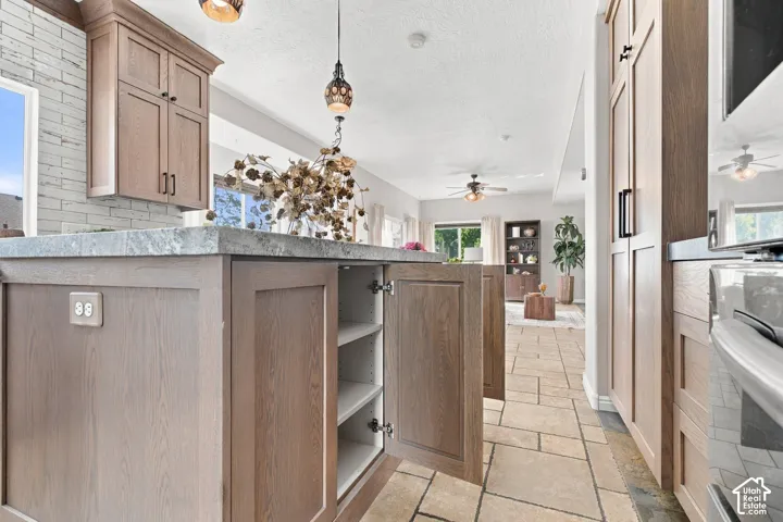 Cabinets with shelves on one side of the island and cabinets, hidden trash and drawers on other side.