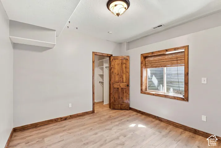 5th bedroom in daylight basement with matching alder door, window and baseboards.  Through closet is the high effenciency furnace and large crawl space storage.