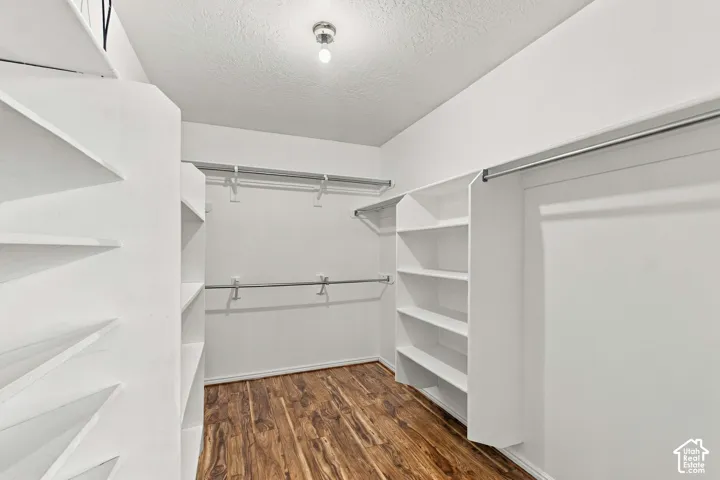 Spacious walk in closet with plenty of shelving in primary suite.