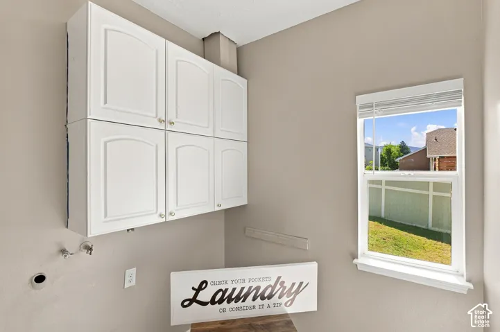 Laundry room with laundry chute going into the cabinet on the right.