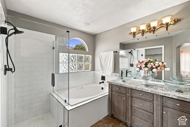 Dual vanity with granite countertop, glass bowl sinks and elegant vanity.  frameless glass shower, separate soaking tub with coordinated matte black fixtures.