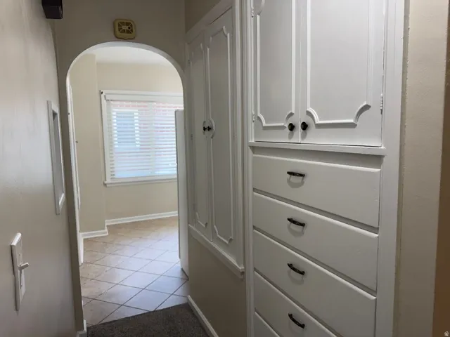 Built-in white cabinetry with decorative upper doors and lower drawer storage