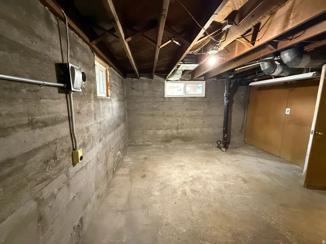 Concrete flooring, exposed ceiling beams, multiple windows, built-in electrical conduit