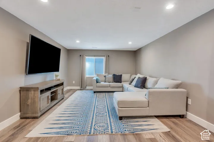Recessed lighting, wood-finish flooring, neutral wall tones, window with natural light, and ample floor space