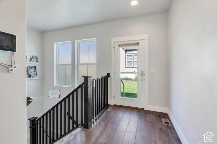 Wood-finish flooring, recessed lighting, white trim, and a glass-paneled exterior door