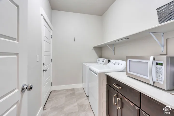 Built-in shelving, dark wood-finish cabinetry, light-toned countertop, and tile flooring