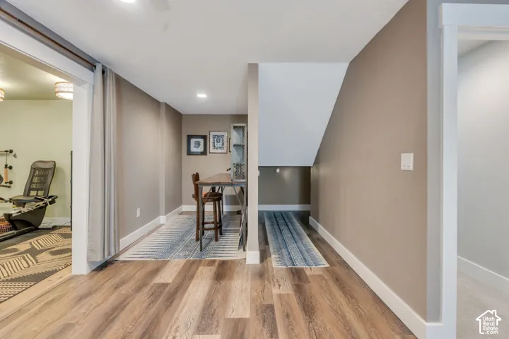 Wood-finish flooring throughout, recessed lighting, and a defined under-stair area