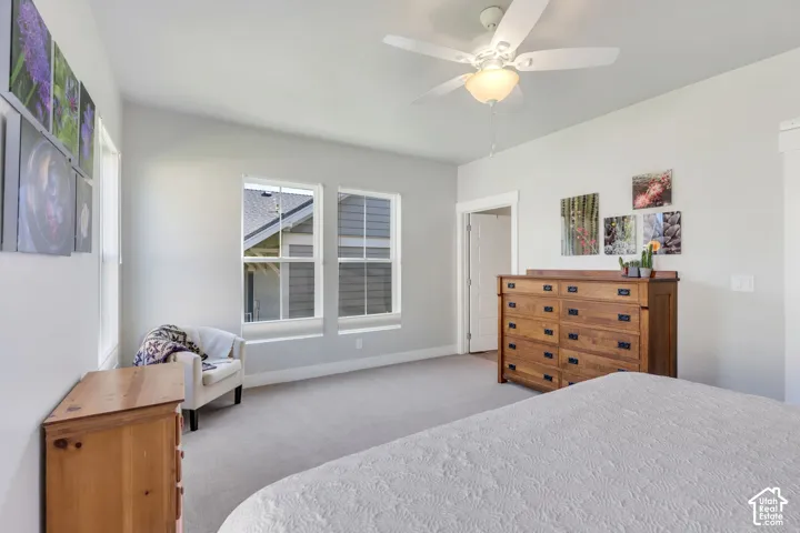 Tray ceiling, recessed lighting, ceiling fan with integrated lighting, carpeted flooring, and two windows