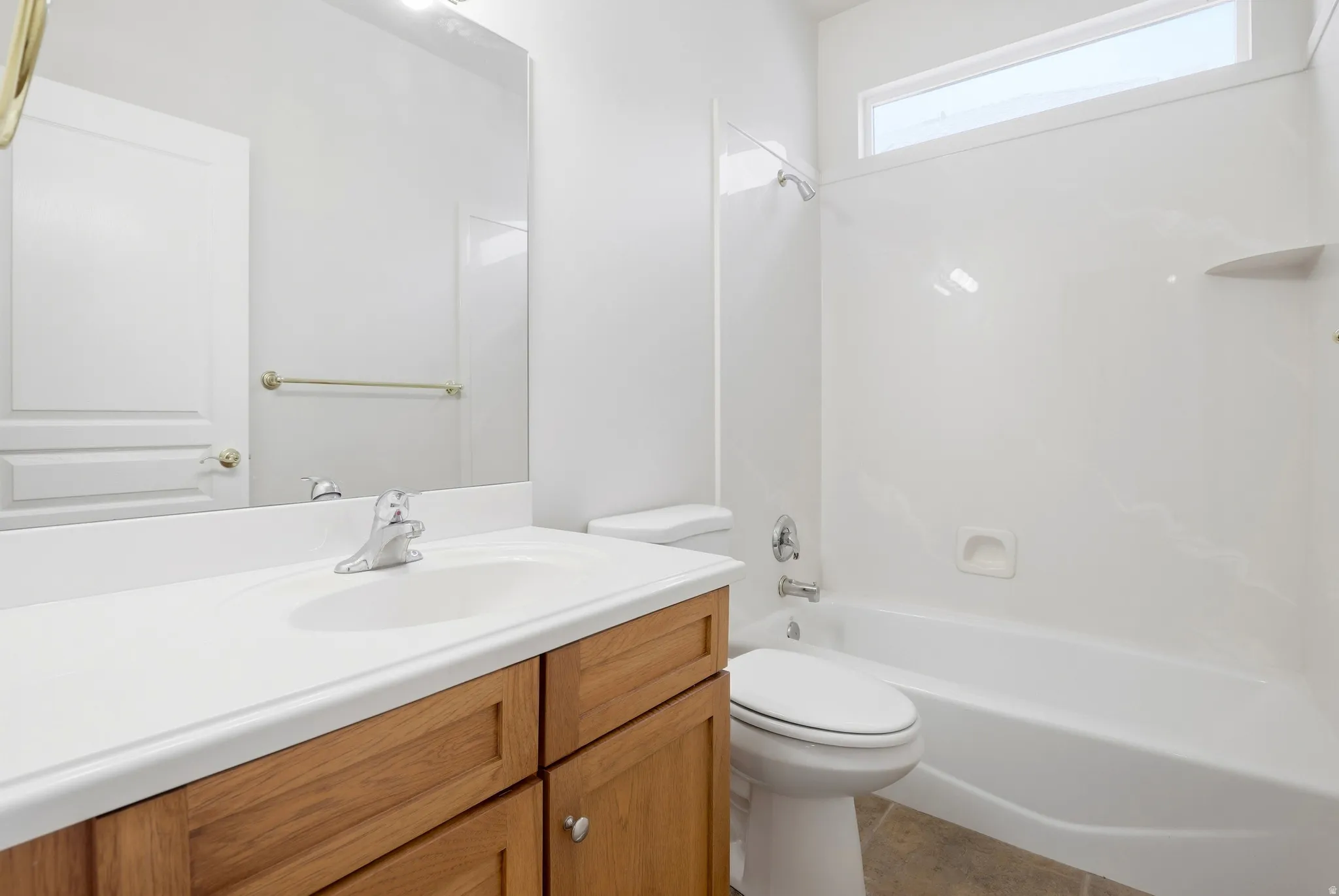 Wood-finish vanity with integrated sink, chrome faucet, and full-width mirror