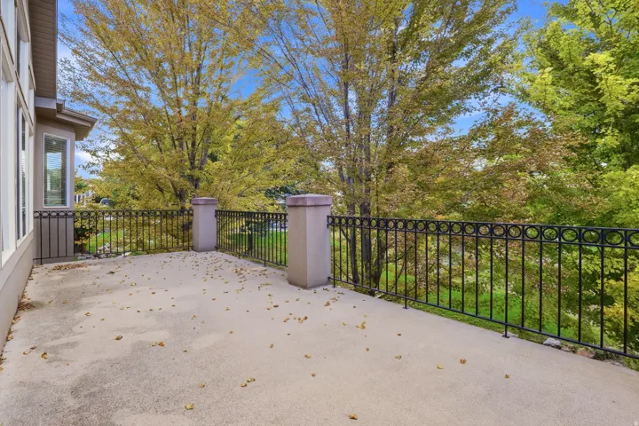 Spacious outdoor patio with decorative metal railing and robust pillar accents