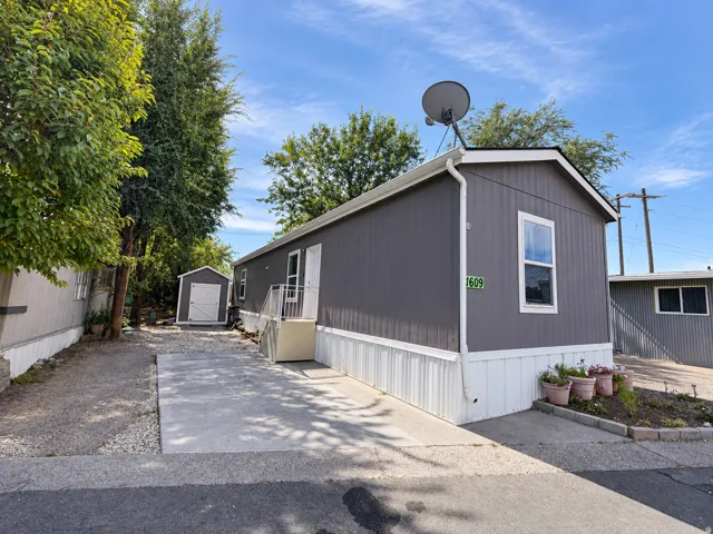 Exterior featuring vertical panel siding, white trim, and a pitched roof