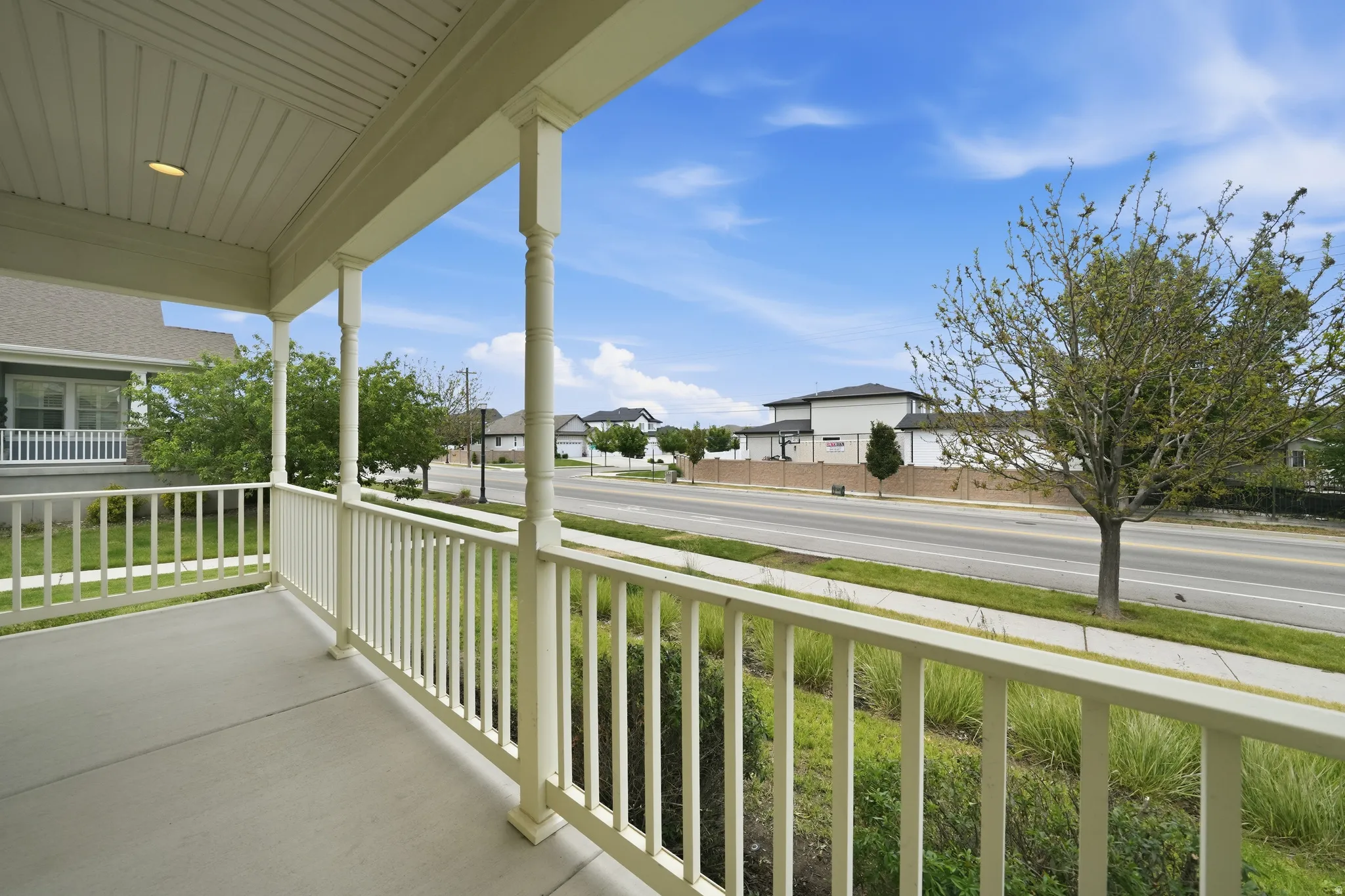 Covered front porch with painted balusters and columns