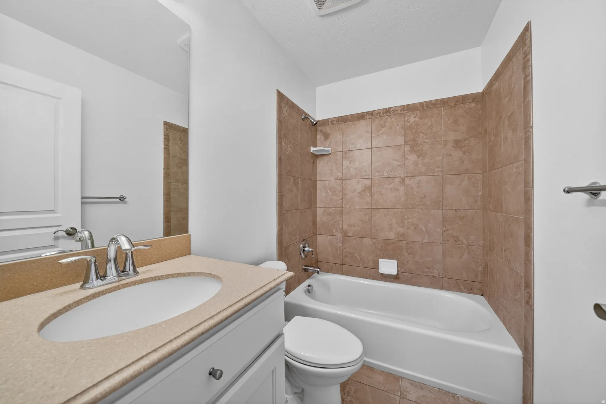 Vanity with integrated sink, chrome faucet, and light-colored countertop
