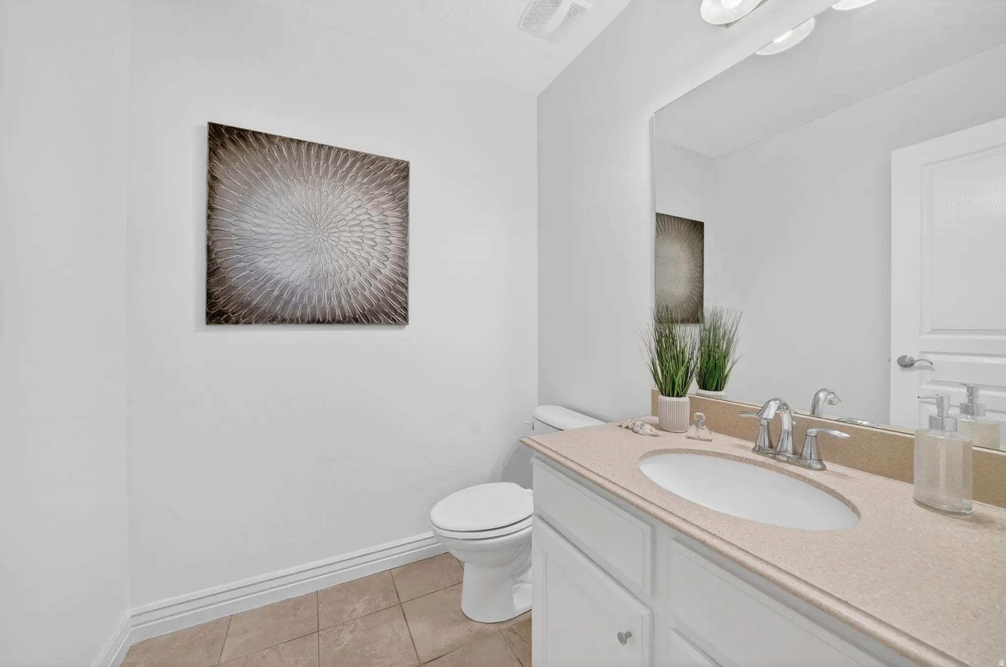 White vanity with brushed nickel hardware, integrated sink, and light-toned countertop