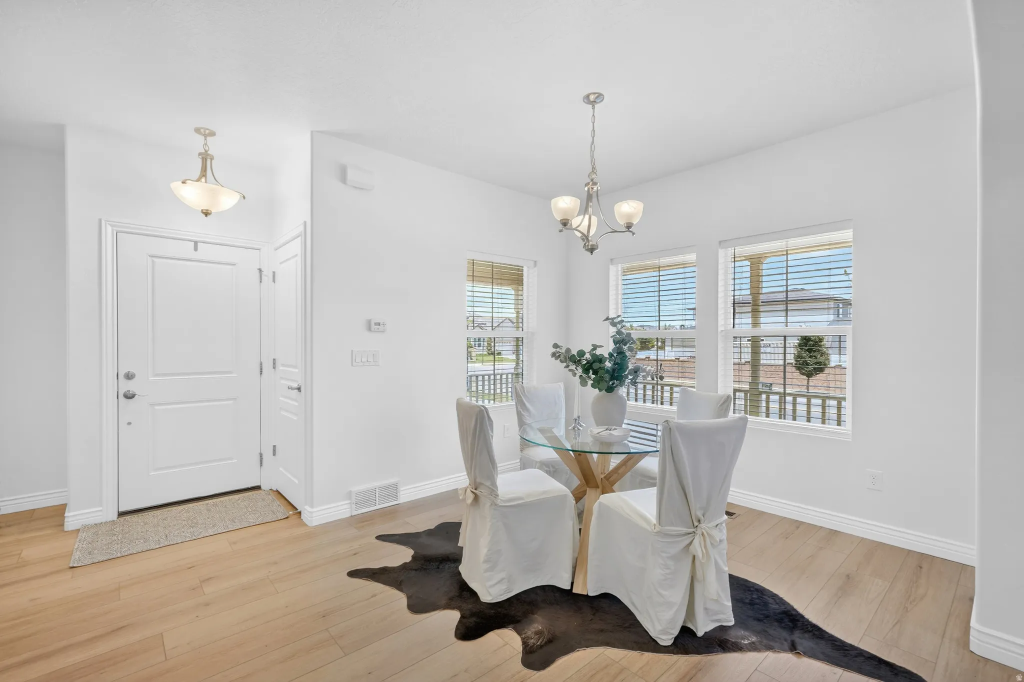 Light wood-finish flooring with white baseboards throughout