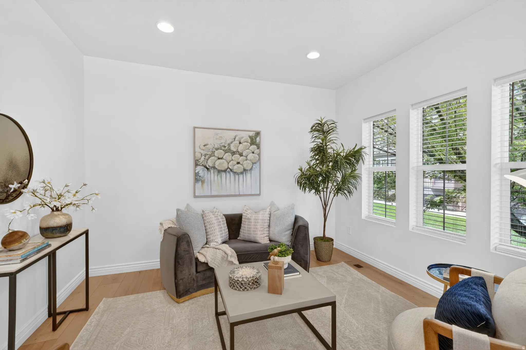 Recessed lighting, wood-finish flooring, multiple windows, and a built-in console table