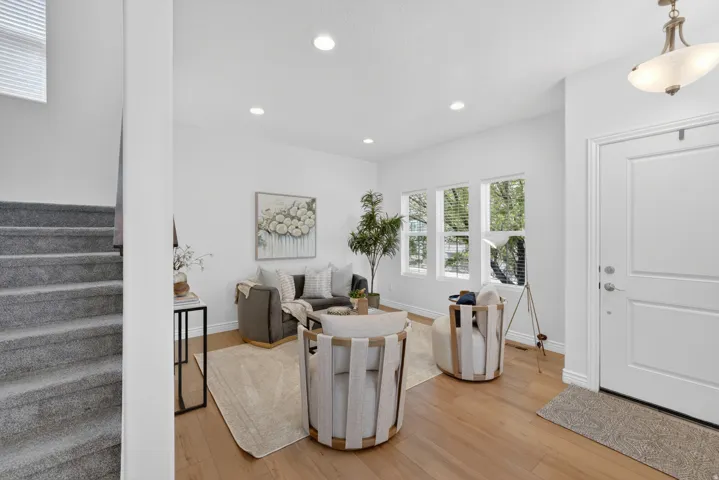 Recessed lighting illuminates the living space with wood-finish flooring